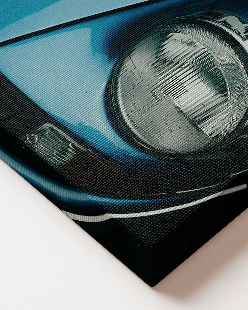 Vertical canvas wall art featuring a close-up of a blue vintage sports car with classic round headlight and retro design details. Close up of canvas material